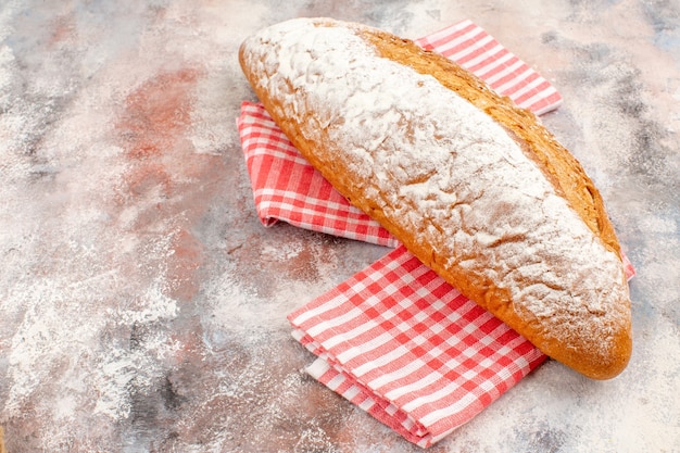 Vista frontale un pane su un asciugamano da cucina rosso su nudo