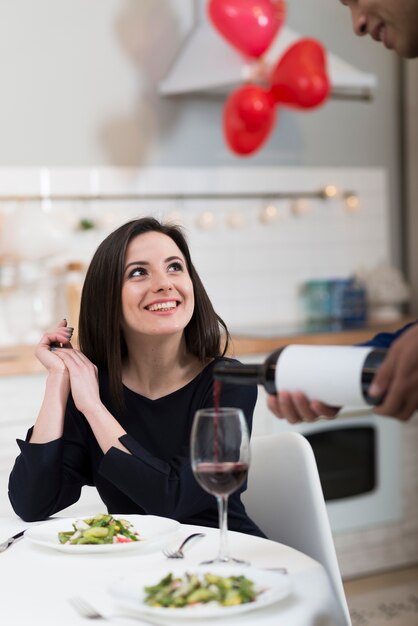 Vista frontale uomo versando il vino in un bicchiere per la sua ragazza