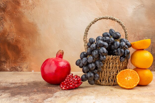 Vista frontale uva nera fresca con arancia su sfondo chiaro foto dolce frutta matura vitamina tree