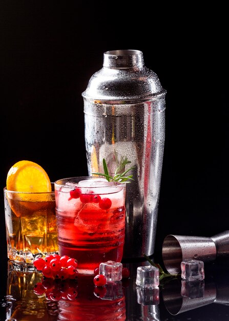 Vista frontale vodka mirtillo rosso e whisky con bicchieri arancioni