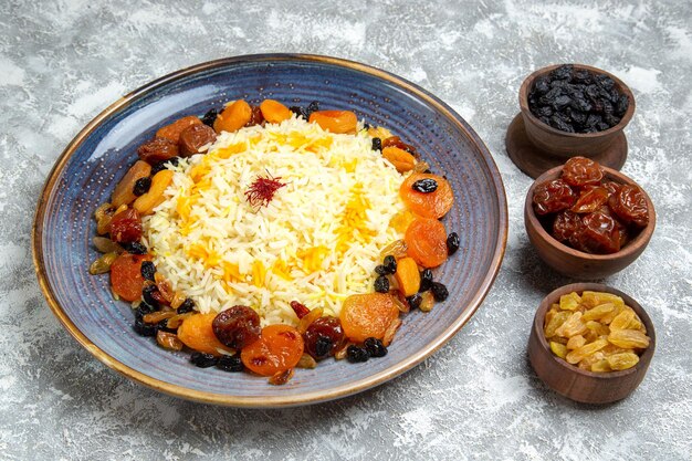 Vista frontale yummy shakh plov piatto di riso cotto con uvetta all'interno del piatto su pavimento bianco cena cucinando piatto di riso
