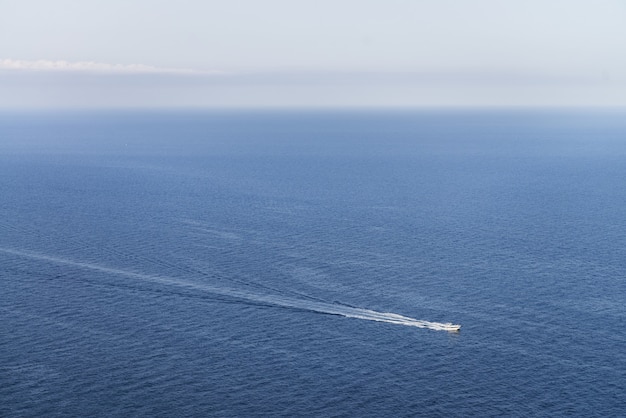 Vista idilliaca di una barca in un oceano blu con uno skyline chiaro - perfetta per la carta da parati