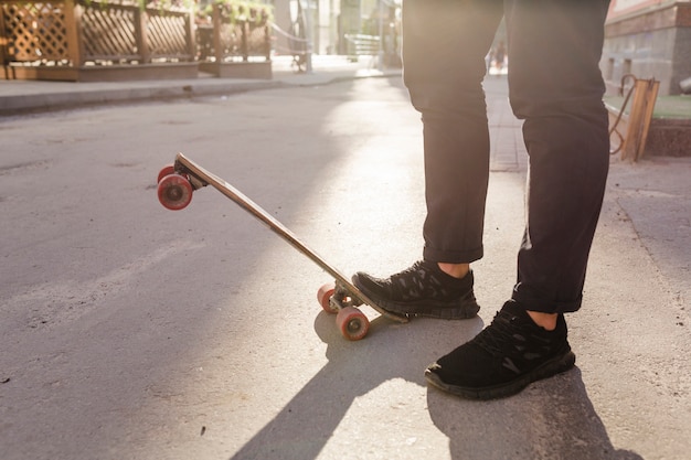 Vista in sezione bassa dei piedi di uno skateboarder su skateboard