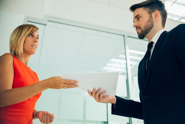 Vista inferiore di collaboratori tenendo gli stessi documenti