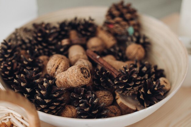 Vista ingrandita dei coni di larice per la decorazione di alcuni piccoli coni caduti di un larice che giace su un piatto di legno come sfondo per l'autunno e il natale