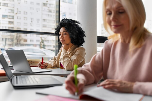 Vista laterale adulti che studiano insieme