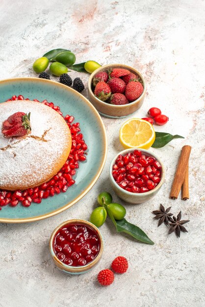 Vista laterale da lontano la torta la torta ai frutti di bosco e marmellata di melograno bacche di cannella al limone