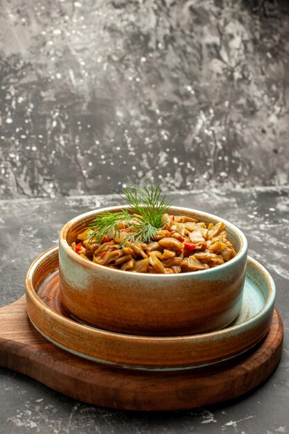 Vista laterale da lontano piatto appetitoso gli appetitosi fagiolini e pomodori sul tagliere sul tavolo nero