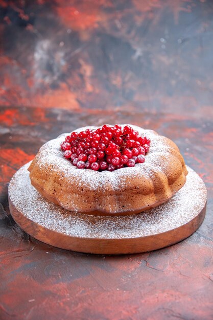 Vista laterale da lontano una torta una torta con ribes rosso sul tagliere