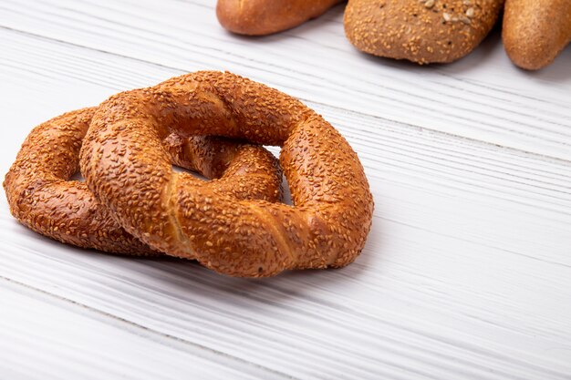 Vista laterale dei bagel dalla parte di sinistra e dal fondo di legno con lo spazio della copia