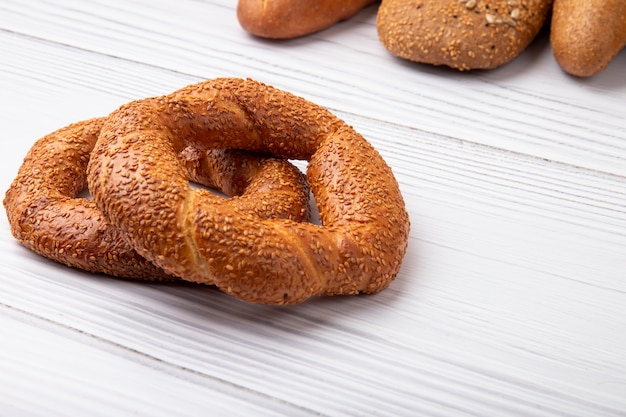 Vista laterale dei bagel dalla parte di sinistra e dal fondo di legno con lo spazio della copia