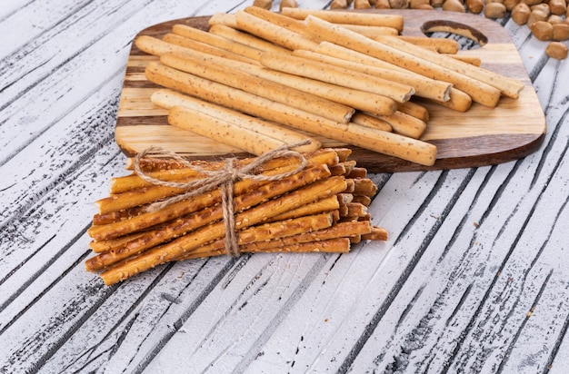 Vista laterale dei cracker sul tagliere di legno sull'orizzontale bianco