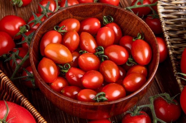 Vista laterale dei pomodori in ciotola sulla tavola di legno