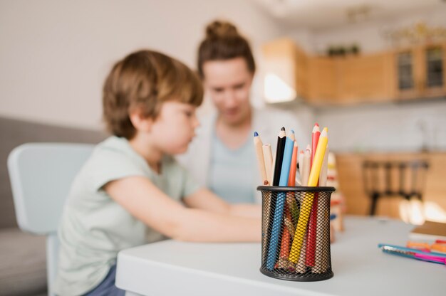 Vista laterale del bambino e tutor a casa prendendo una classe