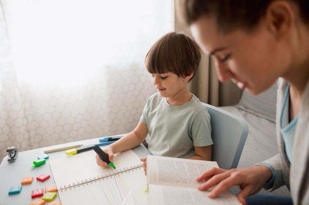 Vista laterale del bambino e tutor a casa