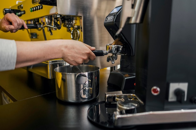 Vista laterale del barista che produce caffè alla macchina