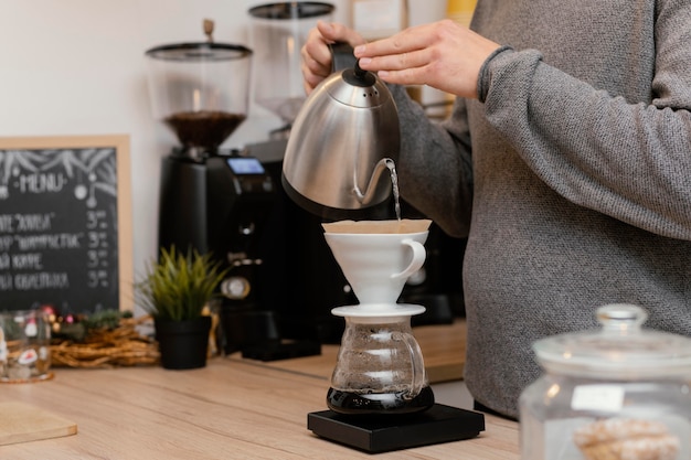 Vista laterale del barista maschio che fa il caffè