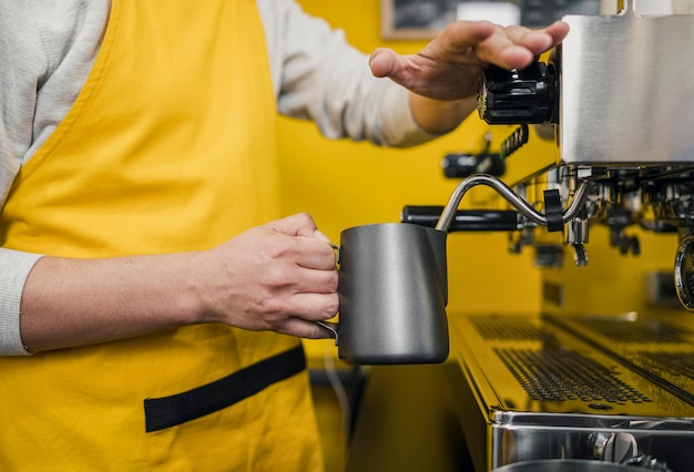 Vista laterale del barista maschio schiuma di latte