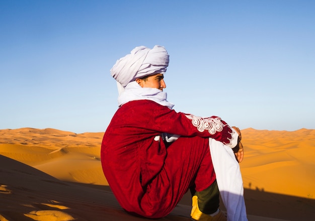 Vista laterale del beduino guardando in lontananza