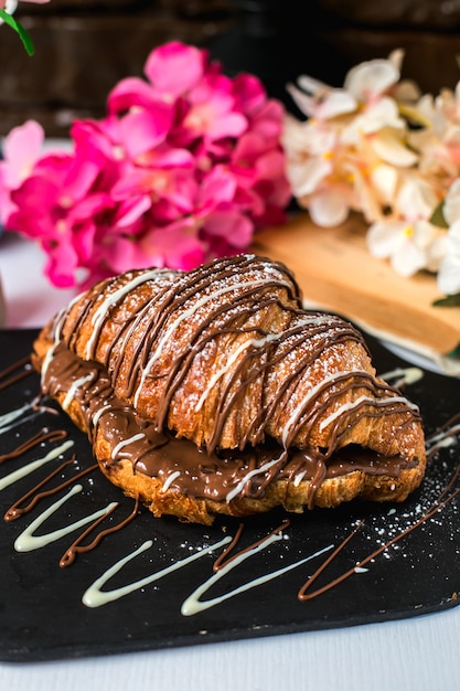 Vista laterale del croissant al forno con cioccolato su una tavola di legno