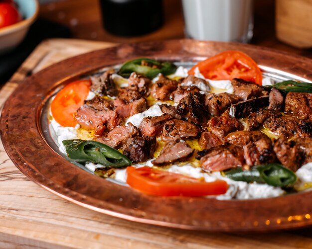 Vista laterale del doner turco tradizionale iskender con yogurt sul piatto