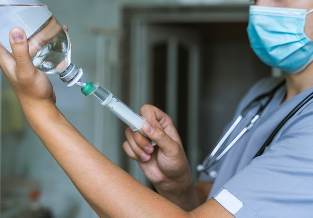 Vista laterale del medico che riempie la siringa con la medicina