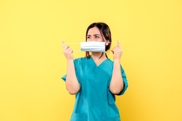 Vista laterale del medico in maschera di usura uniforme medica blu