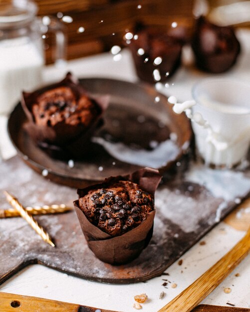 Vista laterale del muffin al cioccolato su un tagliere di legno