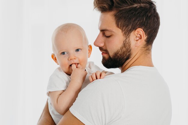 Vista laterale del padre che tiene il suo bambino