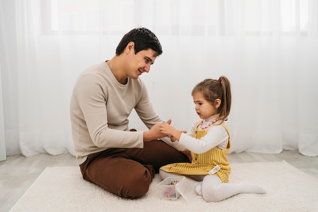 Vista laterale del padre che trascorre del tempo con sua figlia a casa