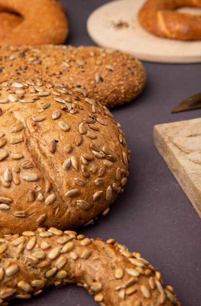 Vista laterale del pane come pannocchia di bagel su sfondo marrone