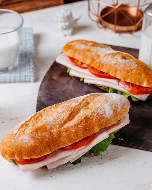 Vista laterale del panino con carne e pomodori sul tavolo