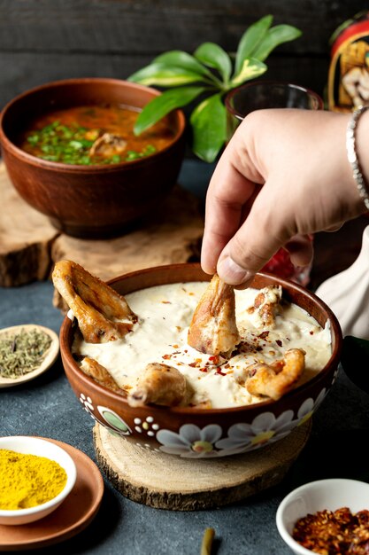 Vista laterale del pollo al forno con formaggio in una ciotola di argilla