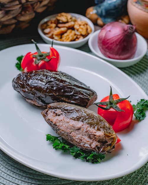 Vista laterale del prezzemolo del pomodoro della carne di dolma della melanzana del piatto nazionale