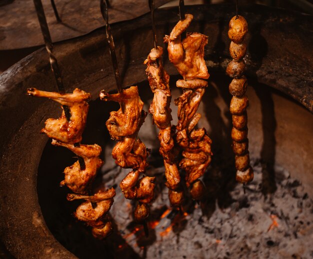 Vista laterale del set di shish kebab al forno in un forno di argilla