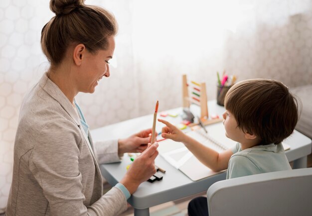 Vista laterale dell'apprendimento a casa del tutor e del bambino