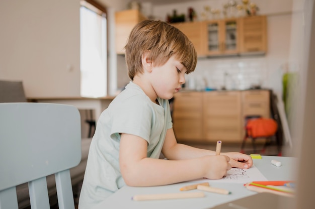 Vista laterale dell'apprendimento del bambino a casa