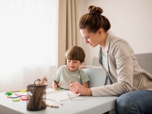 Vista laterale dell'insegnante che insegna al bambino a casa