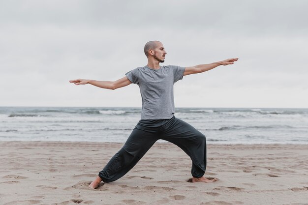 Vista laterale dell'uomo a praticare yoga posizioni all'aperto