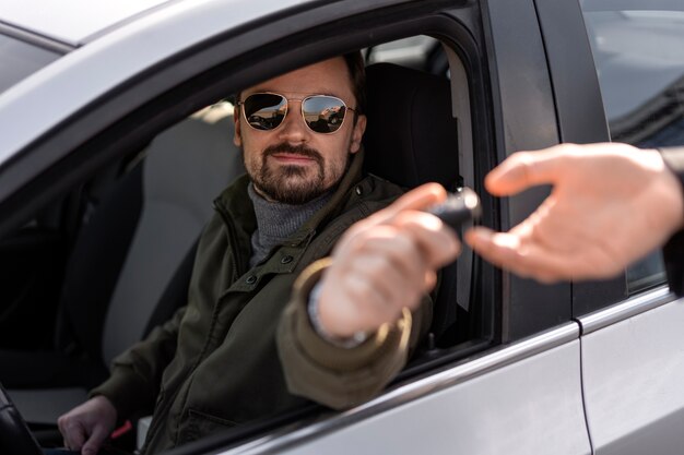 Vista laterale dell'uomo alla guida di un'auto