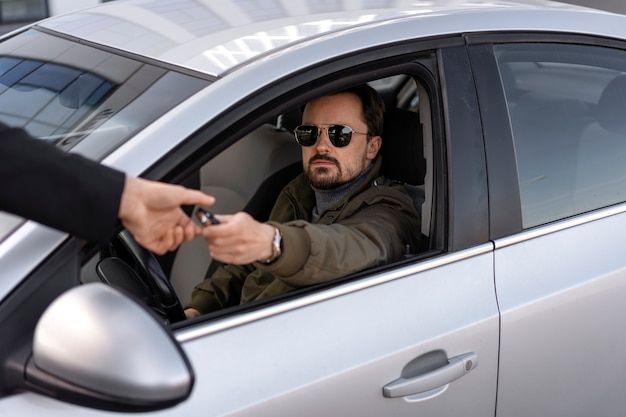 Vista laterale dell'uomo alla guida di un'auto