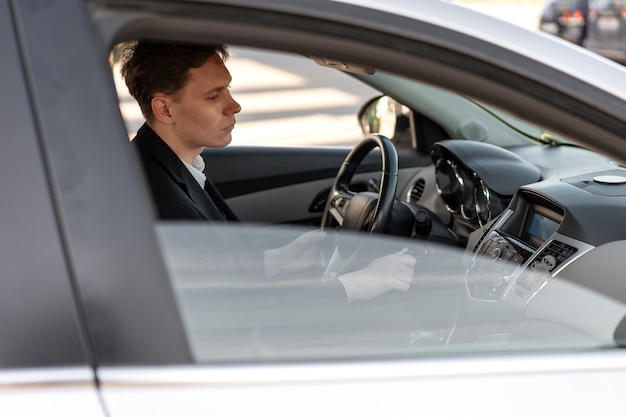 Vista laterale dell'uomo alla guida di un'auto