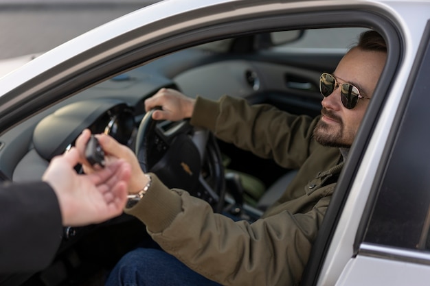 Vista laterale dell'uomo alla guida di un'auto