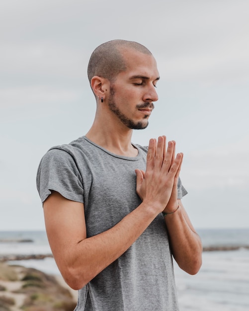 Vista laterale dell'uomo che fa yoga all'aperto