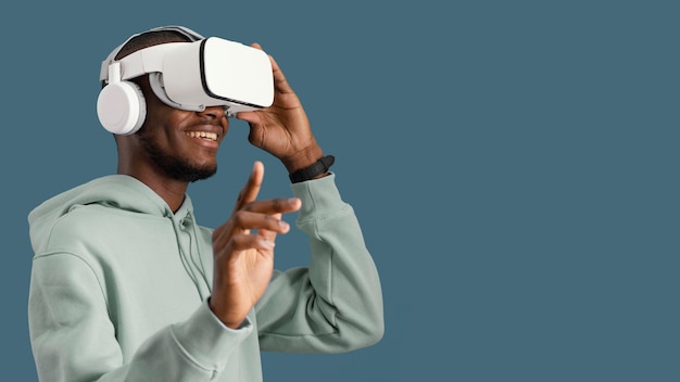 Vista laterale dell'uomo con le cuffie da realtà virtuale e lo spazio della copia
