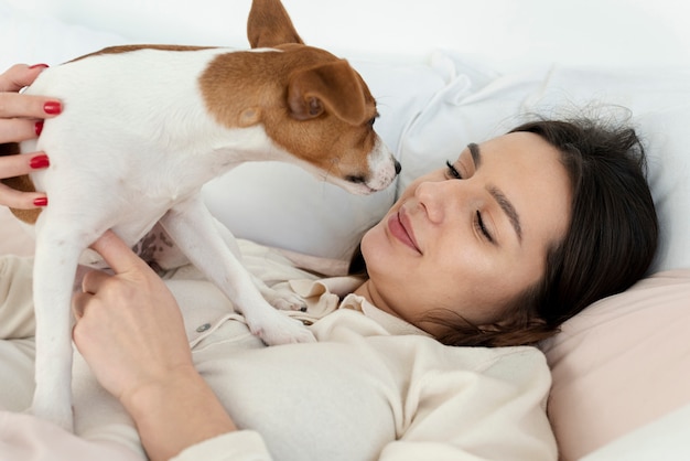 Vista laterale della donna a letto con il suo cane