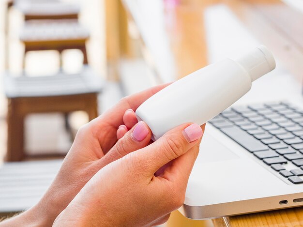 Vista laterale della donna all'aperto che tiene disinfettante per le mani