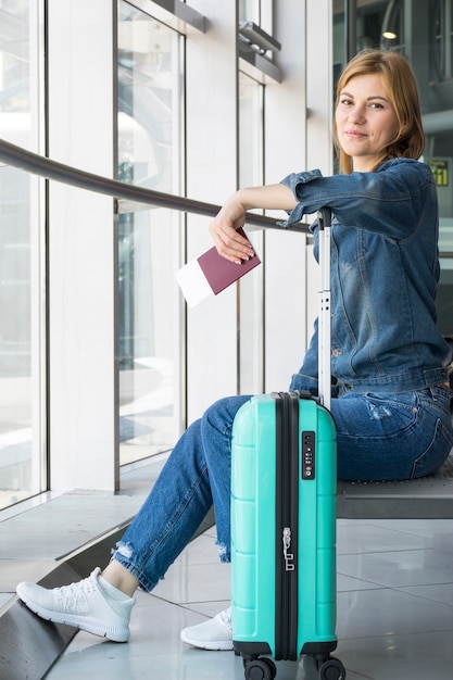 Vista laterale della donna che affronta la macchina fotografica in aeroporto