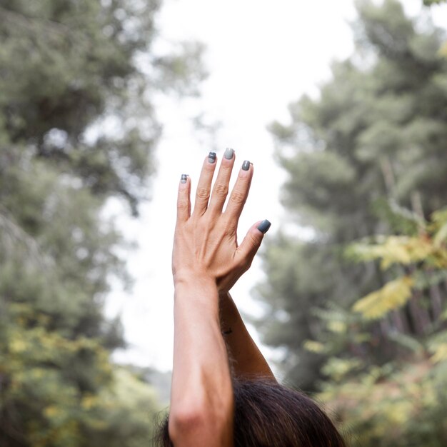 Vista laterale della donna che alza le mani nella posa di yoga all'aperto