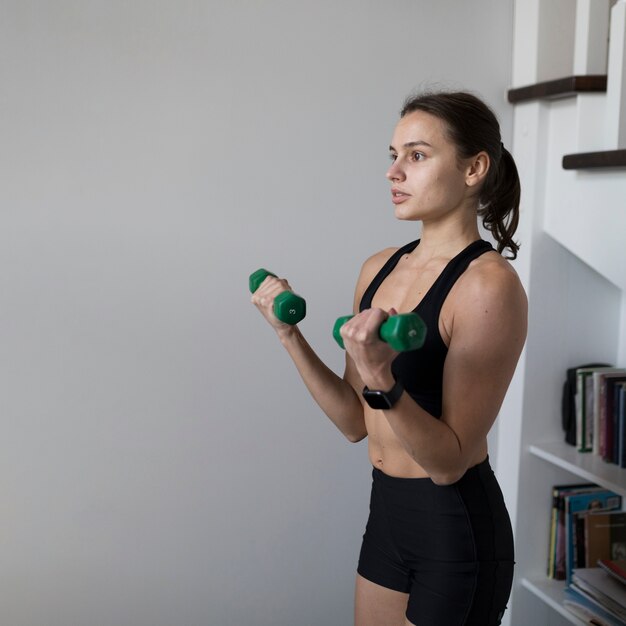 Vista laterale della donna che fa sport a casa